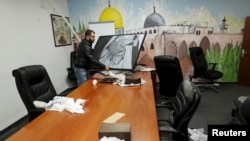 A man carries a photo inside the offices of the The Islamic Movement northern branch in Israel after Israel outlawed the Movement today, in Umm al-Faham, northern Israel, Nov. 17, 2015.