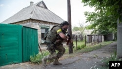Ukrainian serviceman holds a gun during fighting in Mariinka, in the region of Donetsk, June 4, 2015.