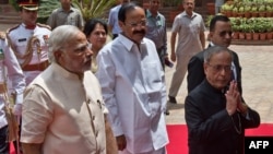 Indian President Pranab Mukherjee (R) arrives with Indian Prime Minster Narendra Modi (L) to address the joint session of Parliament in New Delhi, June 9, 2014. 