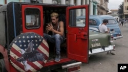 A person uses a cellphone inside a private cab in Havana, Cuba, Jan. 15, 2025. 