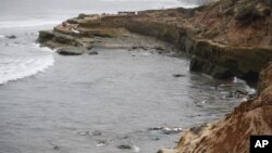 Puing-puing kapal yang terbalik dan terbawa ombak ke pantai di Cabrillo National Monument, tak jauh dari lokasi kapal terbalik di lepas pantai San Diego, Minggu, 2 Mei 2021.