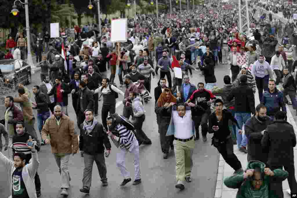 Egyptian President Mohammed Morsi’s supporters clash with opponents, not pictured, outside the presidential palace, in Cairo, Egypt, Dec. 5, 2012.