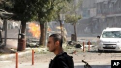 A security member stands after a car bomb attack in the city center of Van, eastern Turkey, Sept. 12, 2016. 