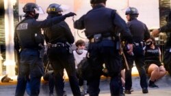 Police officers detain demonstrators in Oakland, California, June 1, 2020.