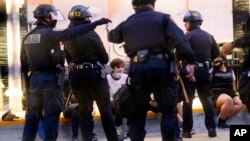 Police officers detain demonstrators in Oakland, California, June 1, 2020.