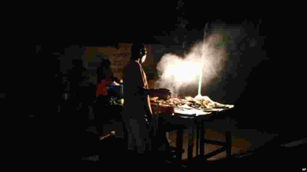 A man cooks suya, a local spicy meat dish.