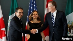 Mexico's Economy Minister Ildefonso Guajardo, left, shakes hands with U.S. Trade Representative Robert Lighthizer before the start of a trilateral meeting with Canada's Foreign Minister Chrystia Freeland during the third round of NAFTA talks in Ottawa, Ontario, Sept. 27, 2017. The fourth round begins Wednesday near Washington.