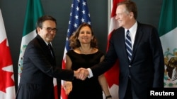 Mexico's Economy Minister Ildefonso Guajardo, left, shakes hands with U.S. Trade Representative Robert Lighthizer before the start of a trilateral meeting with Canada's Foreign Minister Chrystia Freeland during the third round of NAFTA talks in Ottawa, Ontario, Canada, Sept. 27, 2017. 