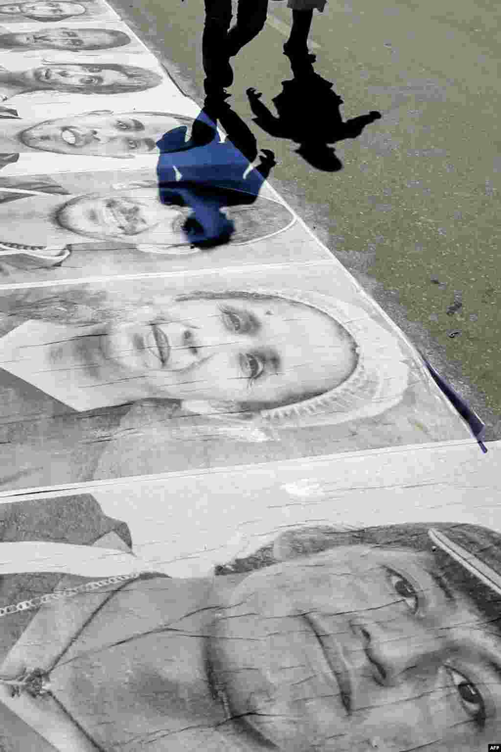 Venezuelans walk past portraits of Venezuelan migrants and refugees displayed along the Simon Bolivar International Bridge in Cucuta, Colombia, as part of the 'Somos Panas' ('We Are Buddies') campaign organized by several NGOs to give visibility and face to people in migratory conditions.