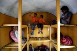 Siddharth Dhage, 10, and his neighbor Gaurav Ganesh, 13, sit in the luggage compartment of a train on their journey back to Mukundwadi railway station, in Aurangabad, India, July 18, 2019.