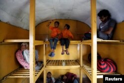 Siddharth Dhage, 10, and his neighbor Gaurav Ganesh, 13, sit in the luggage compartment of a train on their journey back to Mukundwadi railway station, in Aurangabad, India, July 18, 2019.