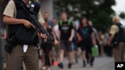 La police escorte quelques personnes qui quittent le centre commercial Olympia après une fusillade, à Munich, Allemagne, 22 juillet 2016. 