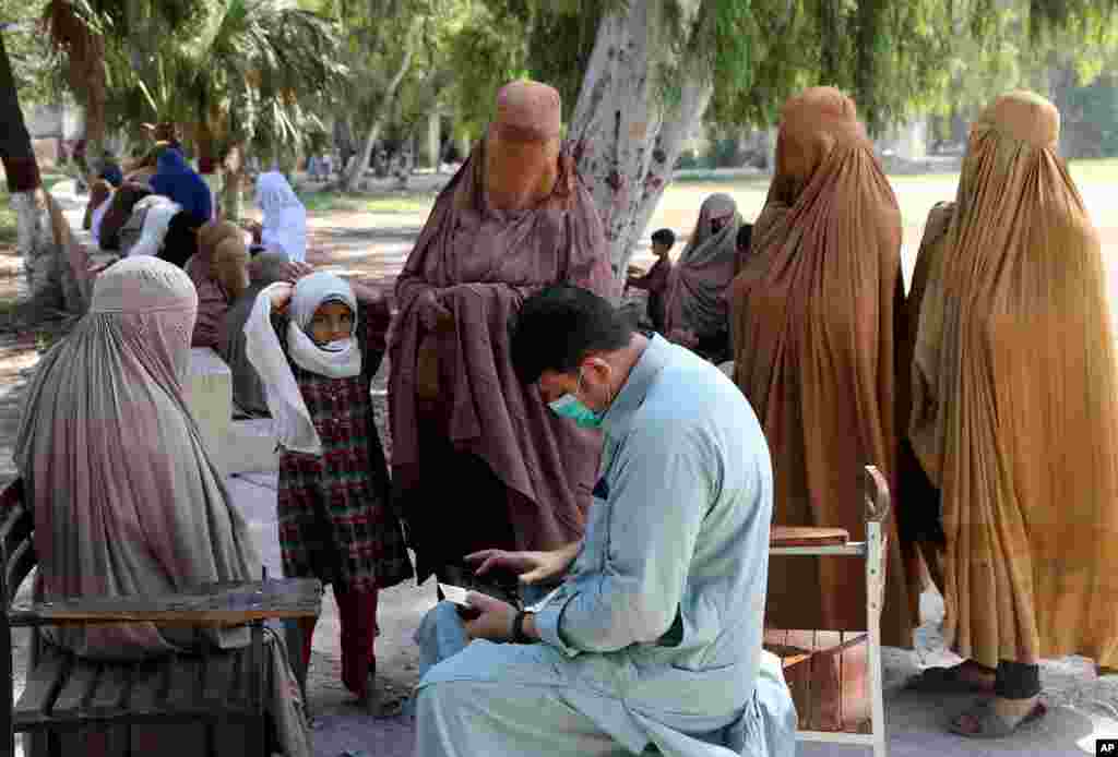 صف زنان منتظر دریافت کمک‌های نقدی، تحت یک برنامه دولتی برای افراد محتاج در پیشاور، پاکستان