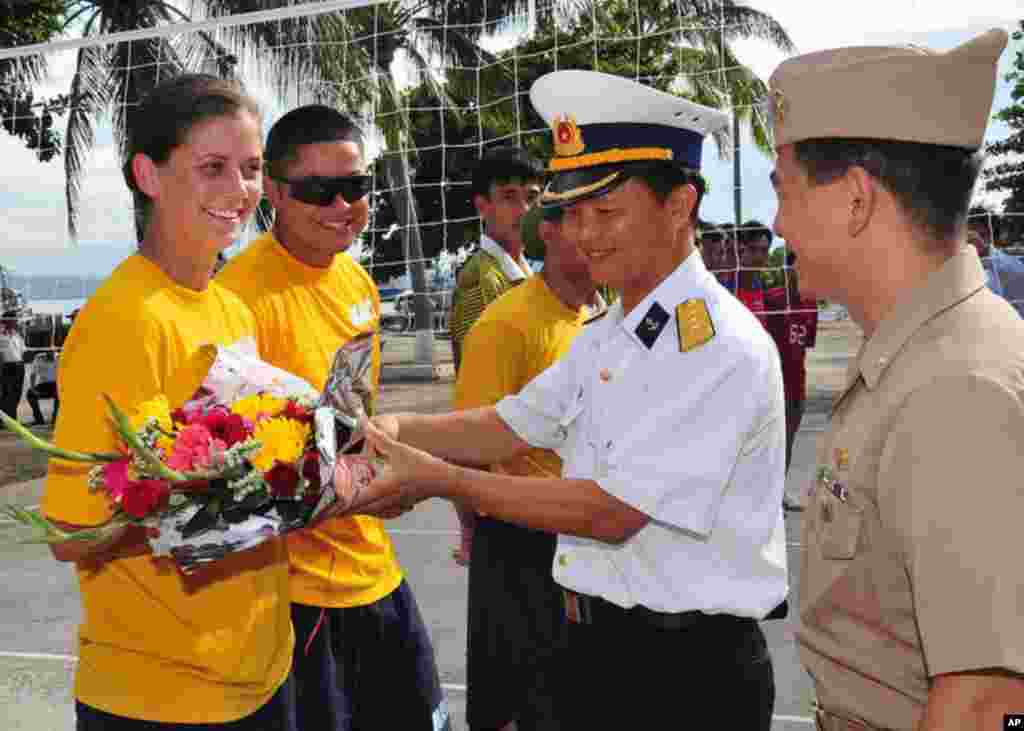 峴港 (7月16日) 普里貝爾號一名水兵在排球賽前接受一名越南軍官獻花。