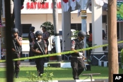 FILE - Members of a police bomb squad examine the area where a suicide bomber blew himself up at the local police headquarters in Solo, Central Java, Indonesia, July 5, 2016. Police said the bomber was a friend of Bahrun Naim, one of the hundreds of Indonesians with IS in Syria and who has been linked to other plots in Indonesia.