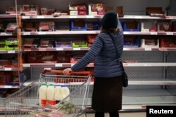 A woman shops at a Sainsbury's store, amid the coronavirus disease (COVID-19) outbreak, in London, Dec. 21, 2020.