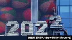 Pekerja menambahkan angka 2 pada angka di atas Times Square menjelang perayaan malam tahun baru di Manhattan, New York City, AS, 26 Desember 2021. (Foto: REUTERS/Andrew Kelly)