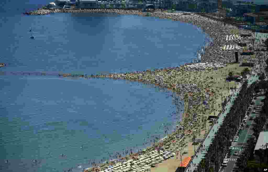 People sunbathe on a beach of Barcelona, Spain.