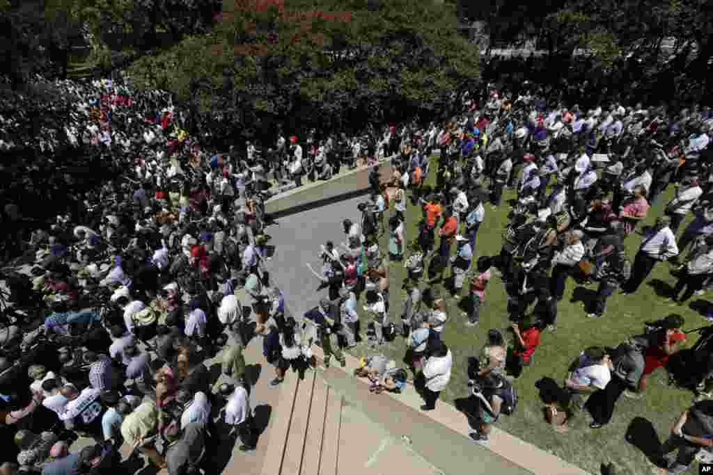 People take part in a prayer vigil at Thanksgiving Square, July 8, 2016, in Dallas.