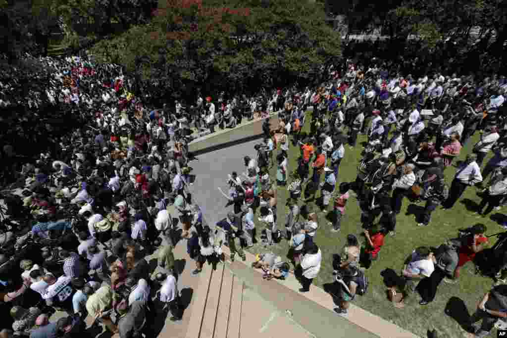 People take part in a prayer vigil at Thanksgiving Square, July 8, 2016, in Dallas. 