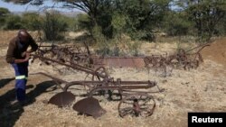 A villager inspects old farming equipment in Moruleng, a small mining community, in Rustenburg, Northwest province, South Africa, June 27, 2018. 