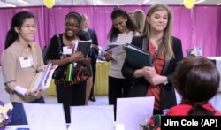 Martina Ryberg, right, of Plymouth State University talks with Tara Rossetti of On Call International during a 2012 job-finding event for college students in Manchester, New Hampshire.