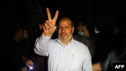 Pemimpin Hamas Khalil al-Haya mengacungkan dua jari membentuk huruf V untuk "victory" (kemenangan) di tengah kegembiraan warga menyambut gencatan senjata antara Israel dan dua kelompok bersenjata Palestina di Jalur Gaza, Kota Gaza, Jumat, 21 Mei 2021. 