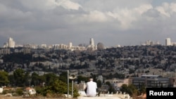 A view of Jerusalem is seen in the background as a man sits in Giv'at HaMatos, a neighborhood on the southern fringes of Jerusalem's city limits where Israel has decided to move forward on a settler housing project, Oct. 2, 2014. 