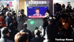 Warga menonton siaran televisi pidato Presiden Korea Selatan Park Geun-hye di stasiun kereta api Seoul (29/11).