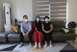 FILE - Ma Seo-bin, center, a high school senior at an elite school, speaks in between her father Ma Moon Young, left, and mother Choi Hae-jeong during an interview at their home in Siheung, South Korea, on Sept. 19, 2020.