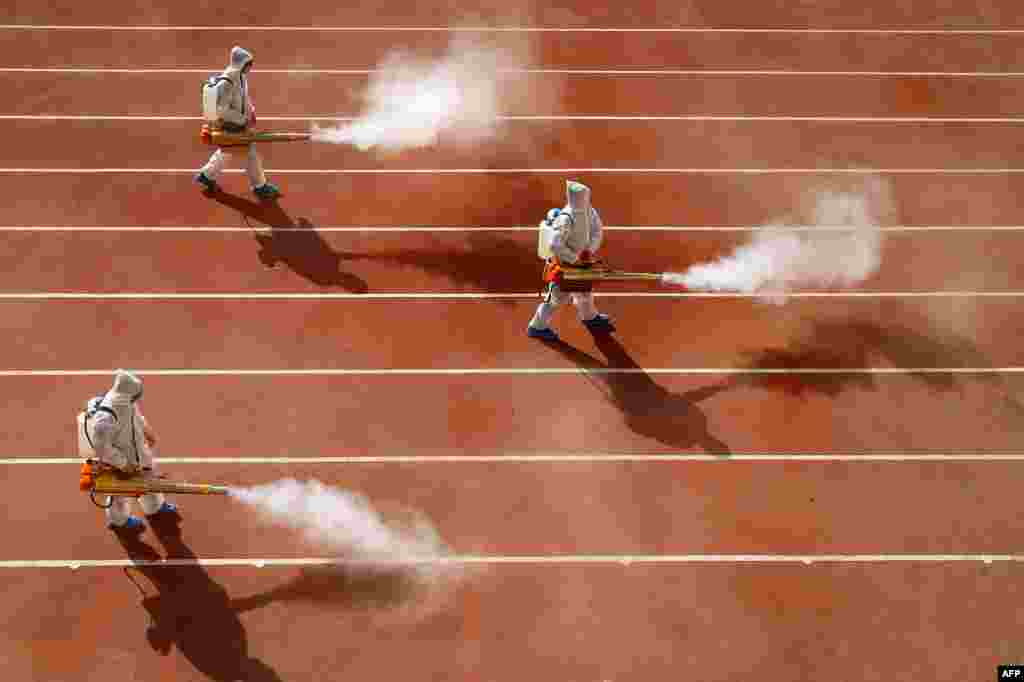Workers spray disinfectant in the playground of a primary school in Huaibei, in eastern China&#39;s Anhui province, as the school prepares for the start of a new term.