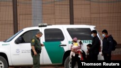 Migrantes son detenidos por un agente de la Patrulla Fronteriza de Estados Unidos después de cruzar el río Bravo, visto desde Ciudad Juárez, el 28 de marzo de 2021..
