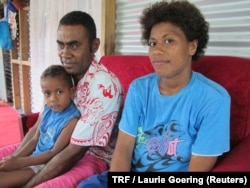 Laisiasa Caukiuai, the headman of Tutua, a village on Fiji's Koro island, sits with his wife Vuladromu Turiagaigusuna and his 3-year-old son Rusiate at a family member's house in Suva, Fiji's capital, Feb. 9, 2018.