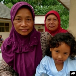 Ibu Parmi sits with friends at Kapuharjo evacuation shelter in Indonesia.