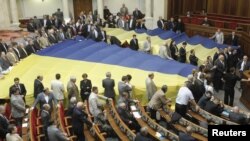 Opposition deputies cover their seats with gigantic national flags to protest against a draft law on languages, which was scheduled to be discussed during a session in the Ukrainian parliament in Kiev