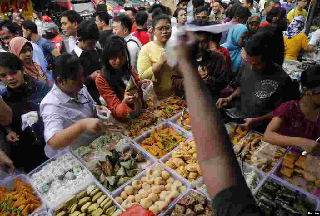 Para pedagang di tepi jalan Bendungan Hilir, Jakarta, menjual makanan berbuka puasa (30/6). (Reuters/Beawiharta)