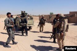 FILE - Afghan Special Forces and policemen prepare for battle with the Taliban on the outskirts of Lashkar Gah, capital of Helmand province, Afghanistan, Oct. 10, 2016. According to a U.S. report, eight out of 14 districts of Helmand province are under insurgent control or influence.