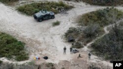FILE - Members of the National Guard patrol along the Rio Grande at the Texas-Mexico border in Rio Grande City, Texas. 