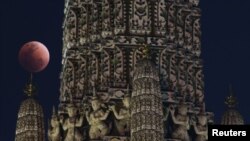 A "super blood blue moon" is seen during an eclipse at a temple in Bangkok, Thailand, Jan. 31, 2018.