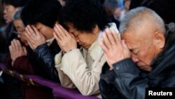 Believers take part in a weekend Mass at an underground Catholic church in Tianjin.