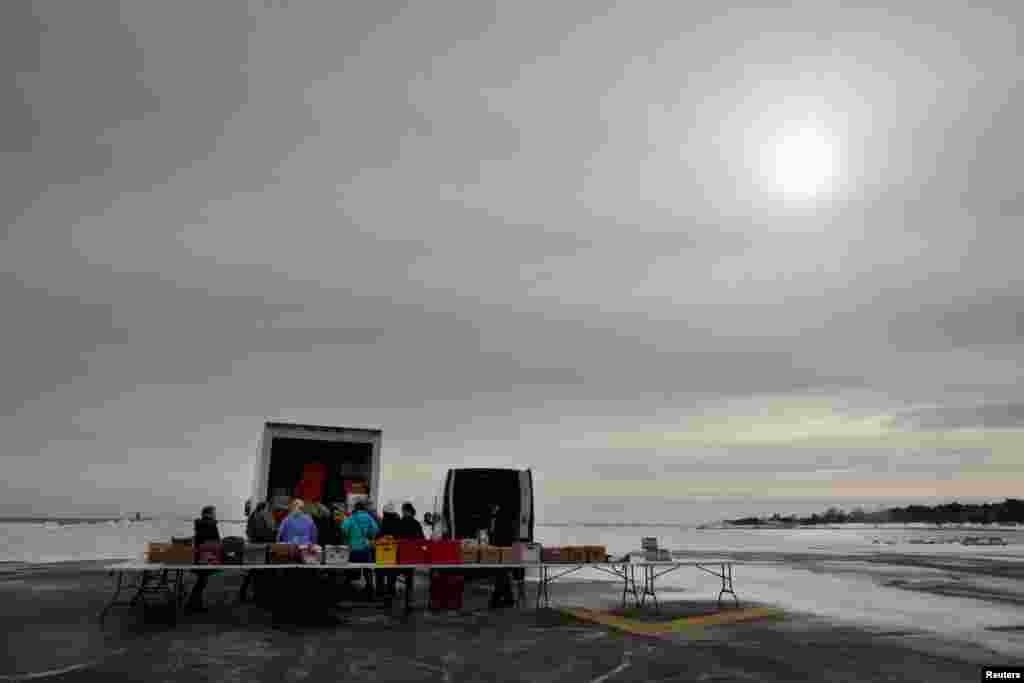 Volunteers and staff of the Gather Food Pantry set up as they prepare to distribute produce, bread, eggs, milk and other supplies to families and members of the U.S. Coast Guard, who are working without pay during the partial government shutdown, at the U.S. Coast Guard Portsmouth Harbor Base in New Castle, New Hampshire, Jan. 23, 2019.