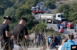 Trucks are parked on the road at a roadblock in Vojtesh, Kosovo, Sept. 9, 2018. Kosovo Albanians burned tires and blocked roads with wooden logs, trucks and heavy machinery on a planned route by Serbia's President Aleksandar Vucic.