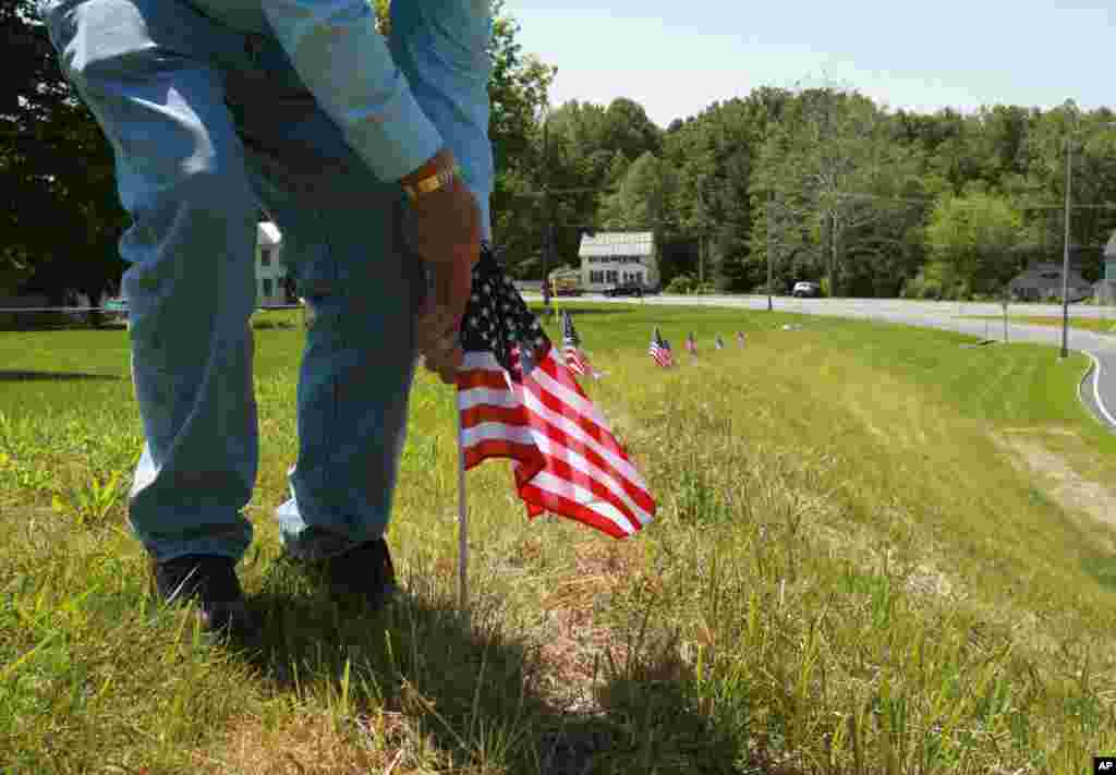 Jim Stull, 78, a life long resident of Thurmont, Maryland, places American flags along an exit ramp that will be traveled by dignitaries motorcading to Camp David for the G8 Summit, May 17, 2012.