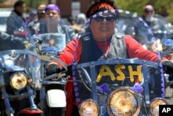 Regina Mike, right, decorated the windshield of her motorcycle in honor of her relative, 11-year-old Ashlynne Mike, as she and hundreds of other motorcyclists escorted the girl's casket following a memorial service in Farmington, N.M., May 6, 2016.