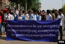 Members of student group led by Srey Chamroeun stand to display their banner demanding responsibility from deputy opposition chief Kem Sokha over his alleged scandalous affair. (Aun Chhengpor/VOA Khmer)