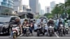 Motorists wait for the green light as tall buildings are seen in the background, at a traffic light stop at the main business district in Jakarta, Indonesia, Jan. 7, 2025. 