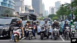 Motorists wait for the green light as tall buildings are seen in the background, at a traffic light stop at the main business district in Jakarta, Indonesia, Jan. 7, 2025. 