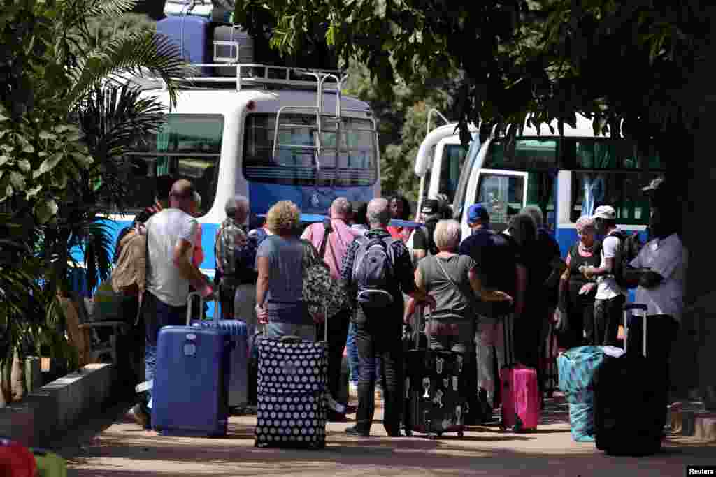 Des touristes se sont réunis pour monter dans des bus et aller à l'aéroport, à Banjul, en Gambie, le 18 janvier 2017.