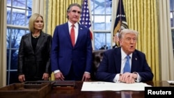 U.S. President Donald Trump signs an executive order in the Oval Office at the White House