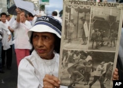 A woman holds up clipping of an old newspaper as she take part in a rally calling for former dictator Manuel Noriega to serve his prison sentence in Panama, in Panama City December 9, 2011.